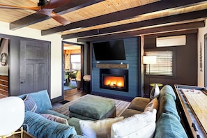 A cozy living room with a fireplace, comfortable seating, and a television. - Cozy Lakefront home in the heart of the White Mountains (Conway)