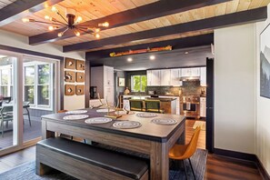 A modern kitchen with a central island, wooden cabinetry, and a built-in oven. - Cozy Lakefront home in the heart of the White Mountains (Conway)
