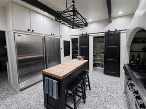 A modern kitchen with stainless steel appliances, a wooden island, and dark cabinetry. - Spacious 5-bedroom house in peaceful Monrovia with AC and gym (Monrovia)