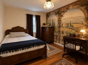 Ein Schlafzimmer mit einem hölzernen Bett, einem Schreibtisch und einem Stuhl. Ein Fenster mit Vorhängen, eine Lampe und ein Wandbild sind ebenfalls vorhanden.