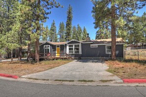 A residential property with a paved driveway, a covered porch, and a stone chimney. - Modern Retreat W Hot Tub & Near Snow Summit (Big Bear Lake)