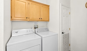 A laundry room with two white front-loading washers and a wooden cabinet above them. - Modern Retreat W Hot Tub & Near Snow Summit (Big Bear Lake)