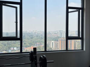 Ein Fitnessstudio mit Blick auf eine Skyline durch große Fenster.