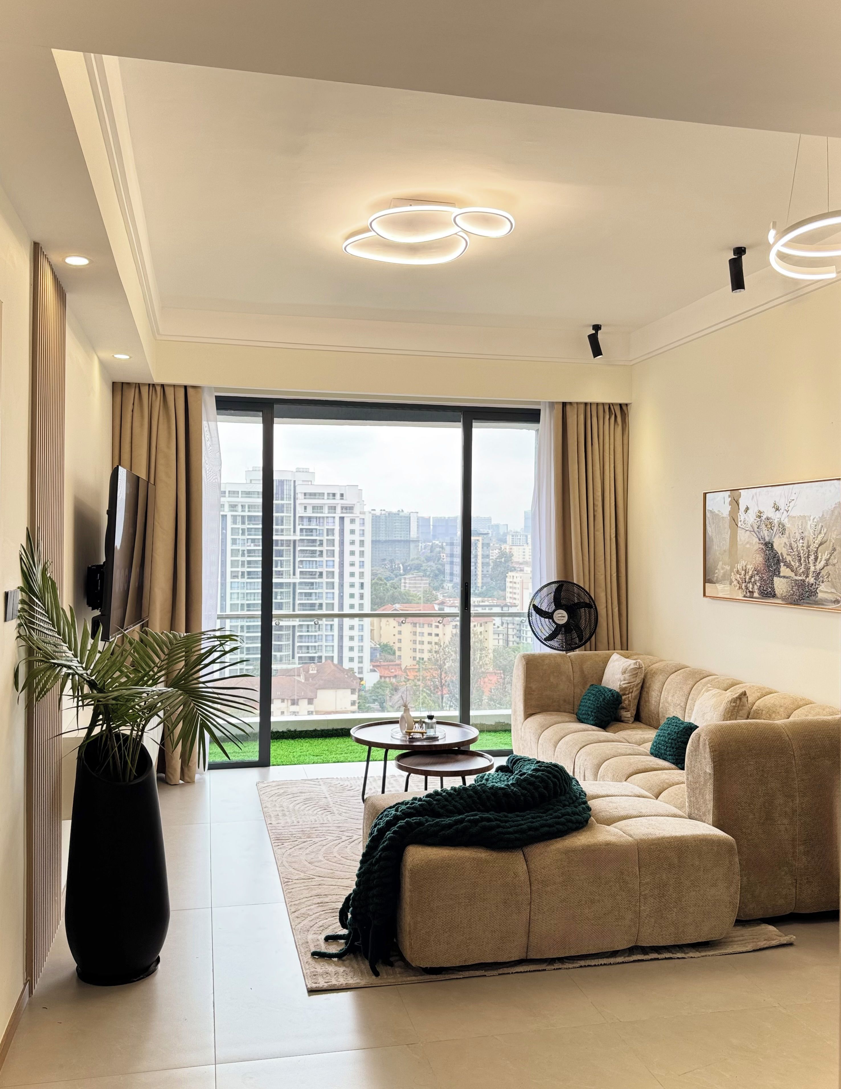 A modern living room with a large window, a sofa, a coffee table, and a floor lamp.