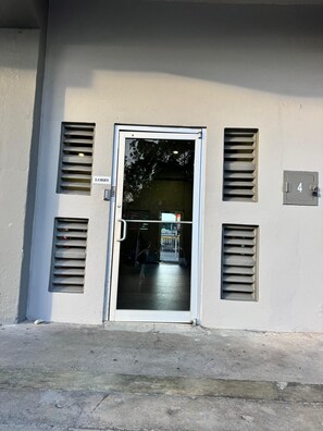 Ein Gebäudeeingang mit einer Tür, einem 'Lobby'-Schild und der Zahl '4' an der Wand.