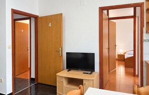 Une chambre d’hôtel avec un bureau en bois, une télévision et un lit.