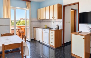 A compact kitchen with a dining area, a television, and a view of the outside. - Nice apartment in Razanac with WiFi (Razanac)