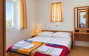 A hotel room with a bed, a nightstand with a lamp, a mirror, and a window with curtains. - Nice apartment in Razanac with WiFi (Razanac)