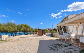 A coastal property with a gravel patio, outdoor seating, and a view of the sea. - Cozy apartment in Razanac with WiFi (Razanac)