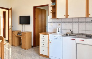 A compact kitchen with a microwave, sink, and cabinets. - 1 bedroom lovely apartment in Razanac (Razanac)