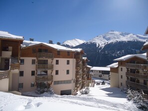 A snow-covered mountain resort with wooden buildings and balconies. - Au pied des pistes | Piscine intérieure chauffée (Aussois)