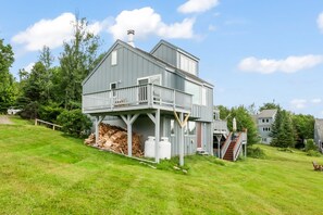 Ein zweistöckiges Haus mit Balkon, einer Veranda und einer Treppe, die zum oberen Stockwerk führt.