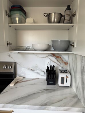 A kitchen with a marble countertop, a toaster, a knife block, and a stove. - Spacious House W/Deck - Near FLL Airport, Beach, Dania Pointe & Hard Rock (Dania Beach)