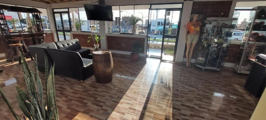 A spacious lobby with a leather sofa, a wooden barrel, and a large window offering a view of the street.