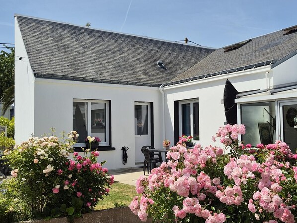 Ein modernes, zweistöckiges Haus mit geneigtem Dach, einer Veranda und einer Garage.