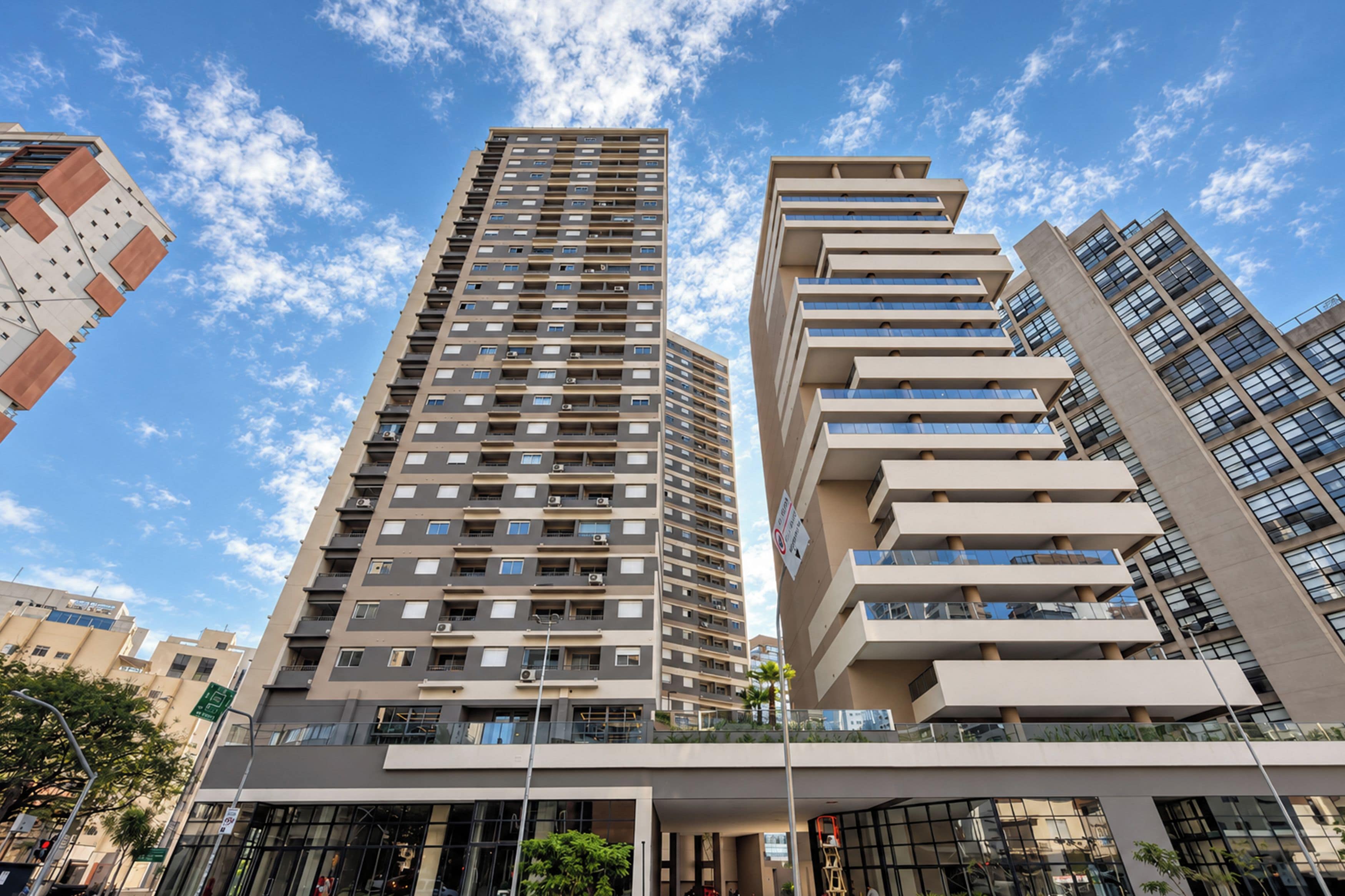 A modern high-rise building with multiple balconies and a clear sky.