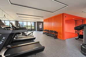A modern gym with a treadmill, dumbbells, and exercise equipment. - Stay Home Itaim - Piscina - Academia (São Paulo)
