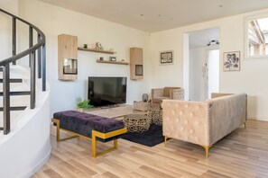 A modern living room with a flat-screen TV, a sofa, a coffee table, and a staircase. - L'Endurance - Proche 24h du Mans (Le Mans)
