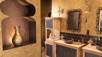 Une salle de bain moderne avec un grand miroir, deux lavabos et un élément décoratif mural.