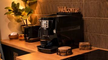 Een koffieapparaat op een houten aanrecht met een 'Welcome'-bord erboven.