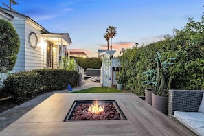 A residential outdoor area with a fire pit, a covered patio, and a view of a house with a white exterior. - PB Hot tub Large Guesthouse + MiniGolf Sleeps 16+ (San Diego)