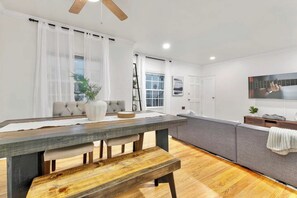 Eine moderne Küche mit einem Holztisch, einer Bank und einem grauen Sofa.