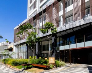 A modern building with a glass facade, a rooftop garden, and a sign indicating a hotel. - Be Urban Metro Brooklin (São Paulo)