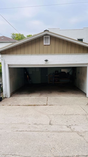 Eine Garage mit geneigtem Dach, einem kleinen Fenster und einem Betonboden.