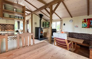 A rustic interior with a wooden dining table, chairs, a sofa, and a fireplace. - 2 bedroom awesome home in Glesborg (Glesborg)