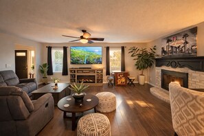 A living room with a fireplace, television, and seating area. - 8BR Vegas Retreat! Strip Views, Pool, Spa, Sauna, Gym, Gameroom +2 Casitas ★★★★★ (Las Vegas)