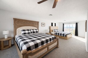 A hotel room with two beds, a ceiling fan, a window with a view, and a small bedside table with a lamp. - 8BR Vegas Retreat! Strip Views, Pool, Spa, Sauna, Gym, Gameroom +2 Casitas ★★★★★ (Las Vegas)