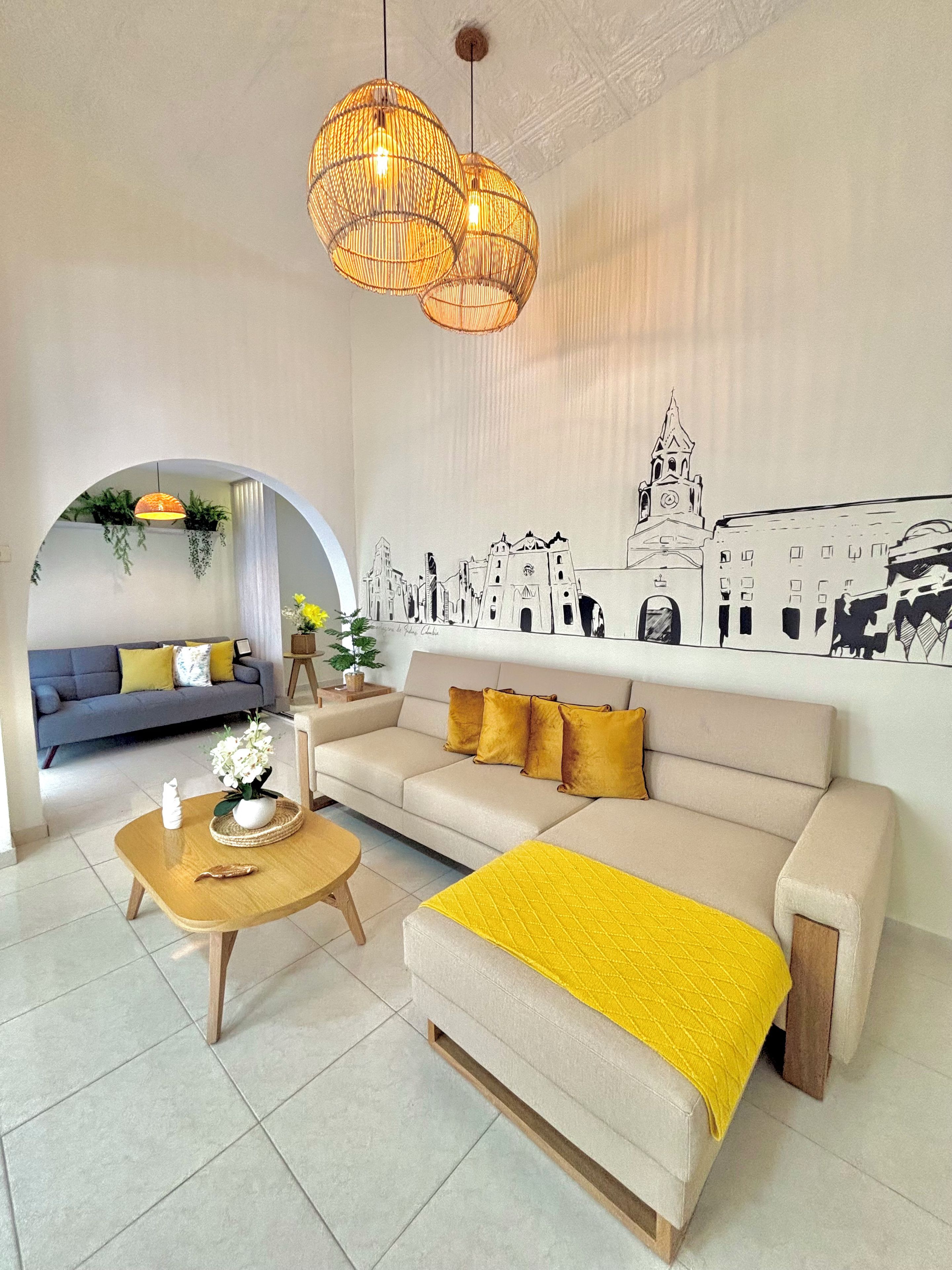 Una sala de estar moderna con un sofá, una mesa de centro y un mural de un paisaje urbano.