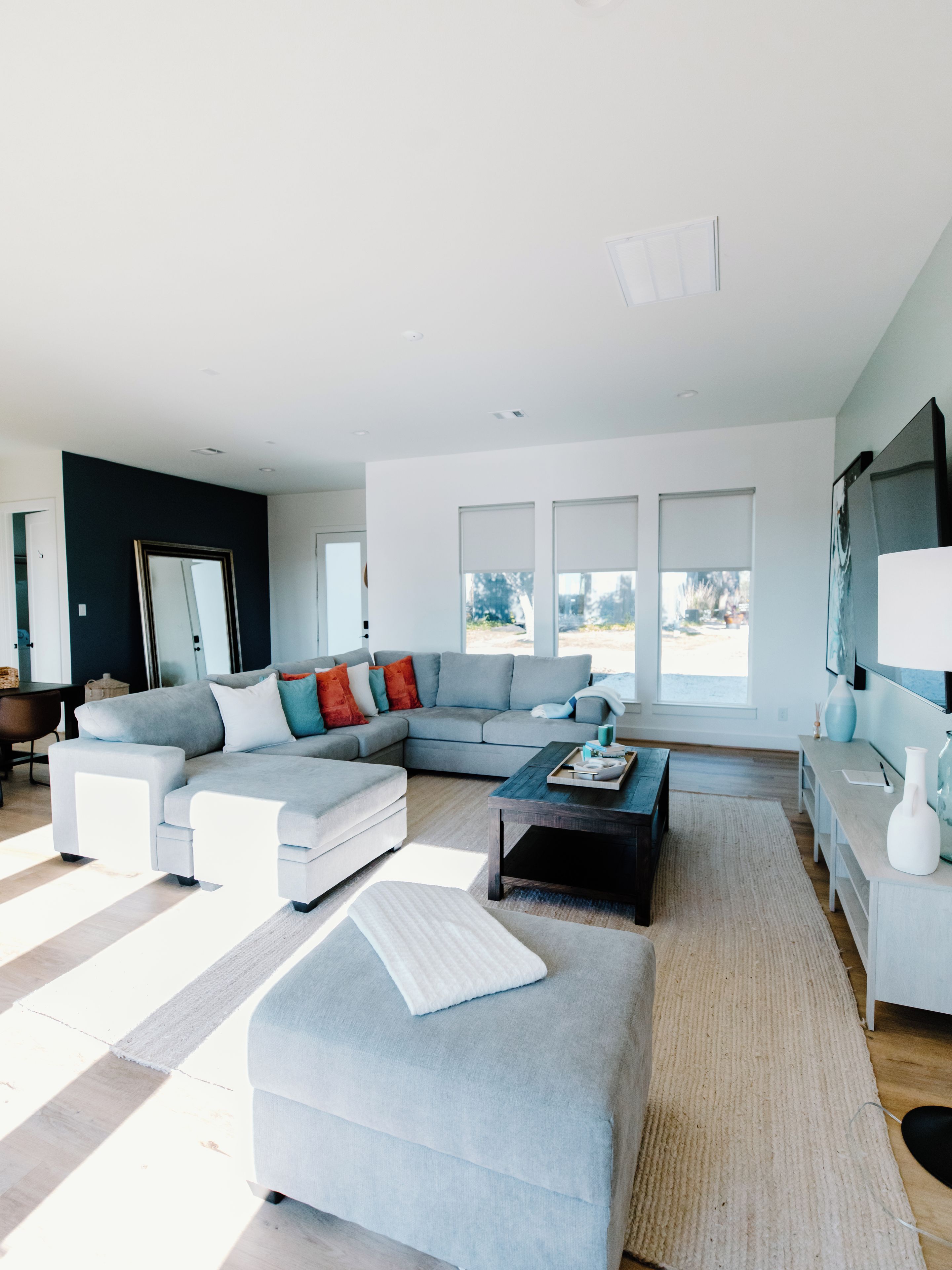 A modern living room with a sectional sofa, a coffee table, and a large window.