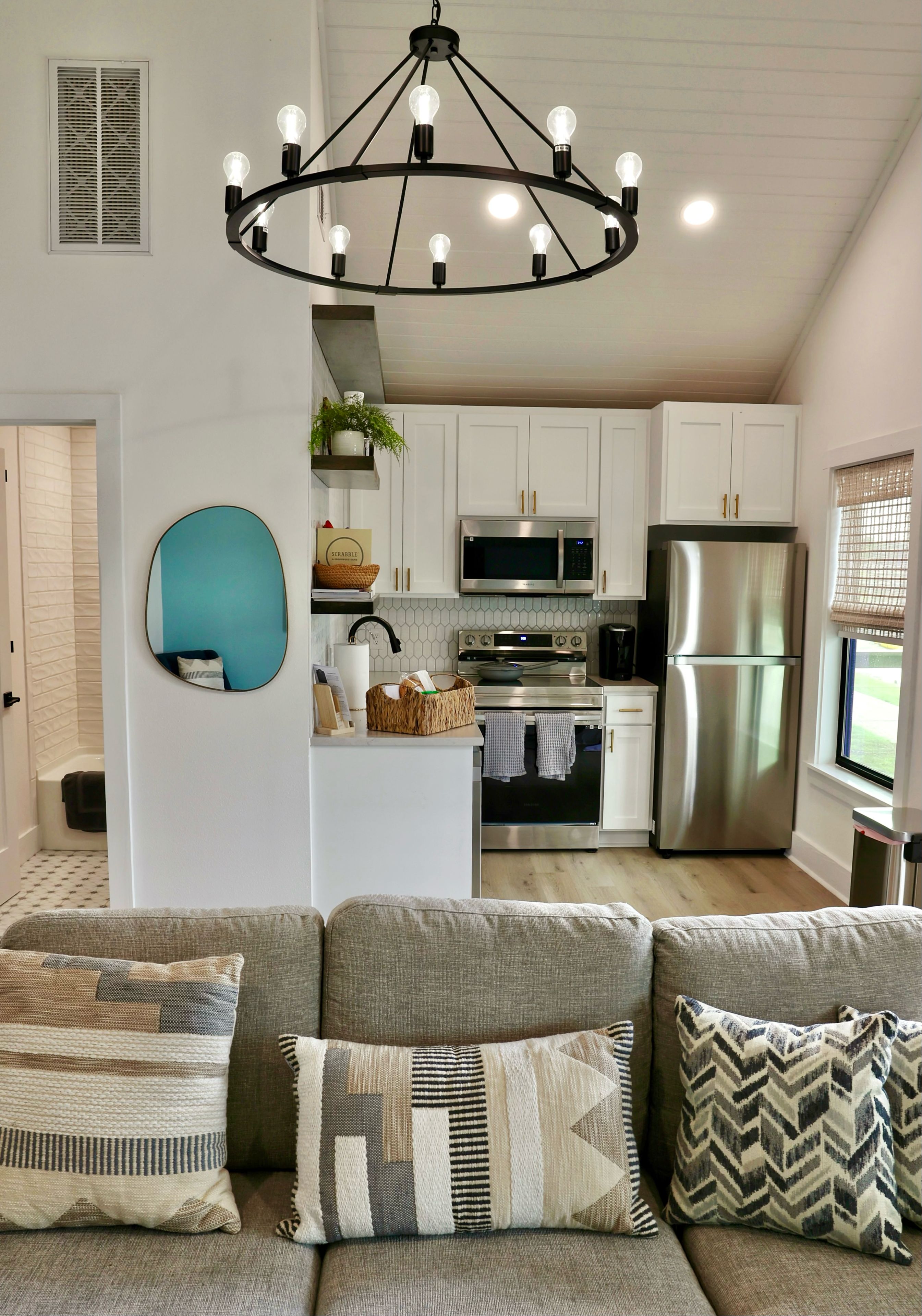 A modern kitchen with white cabinets, stainless steel appliances, and a central island.