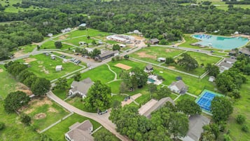 Vista aérea de una zona residencial con casas, piscina y cancha de tenis.