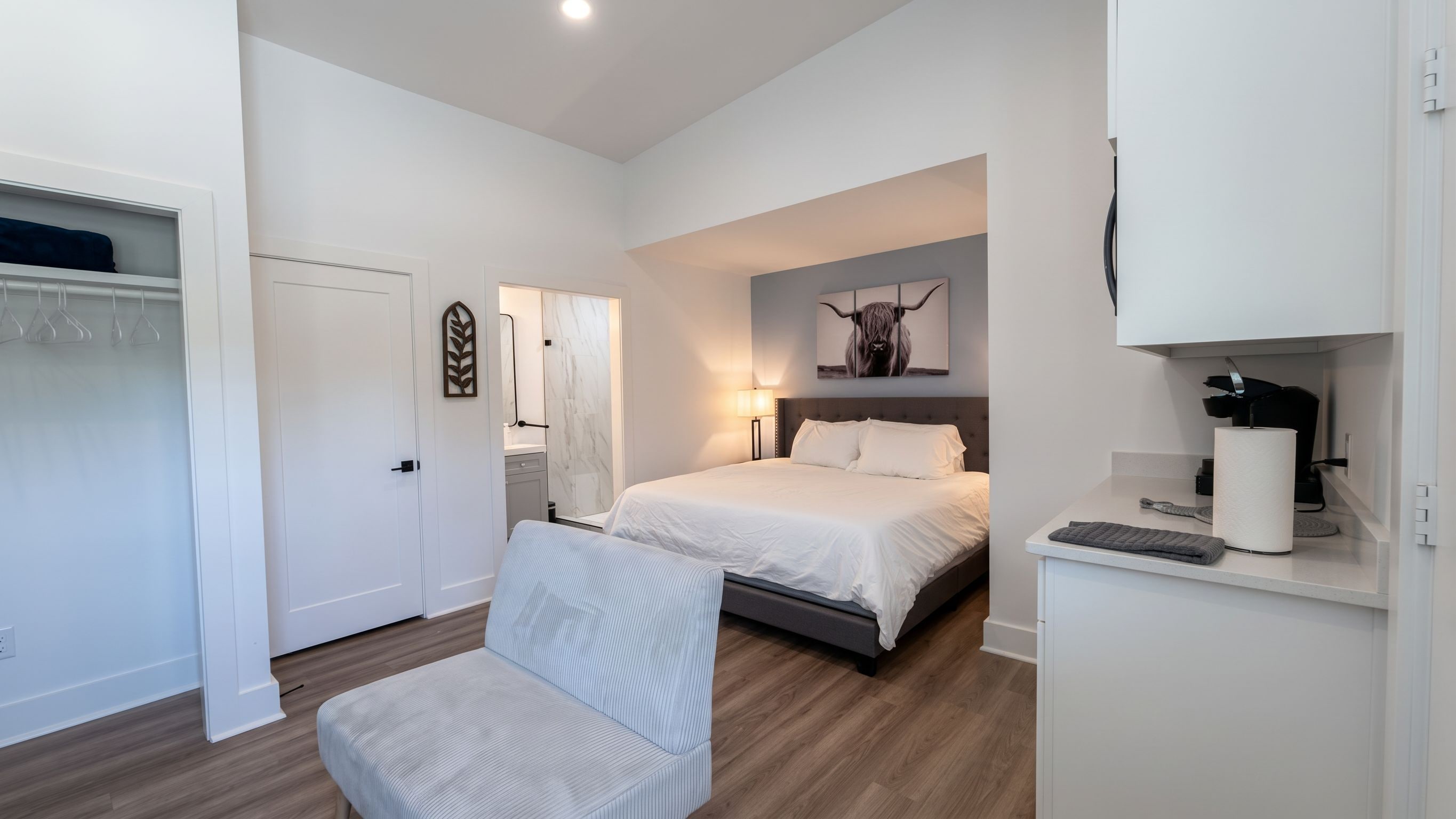 A modern bedroom with a bed, bedside table, and a chair.