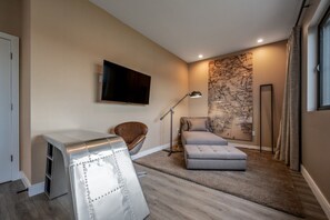 A modern living room with a sofa, a chair, a TV mounted on the wall, and a floor lamp. - Family Getaway Near Disney (Kissimmee)