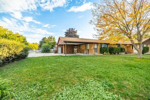 Einbungalow mit Veranda, Garage und gepflegtem Rasen.