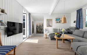 A modern living room with a flat-screen TV, a grey sofa, a wooden coffee table, and a wicker pendant light. - Beautiful home in Slagelse with WiFi (Slagelse)
