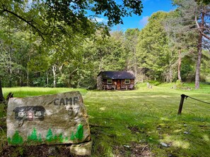 A rustic cabin with a wooden exterior, surrounded by lush greenery and trees.