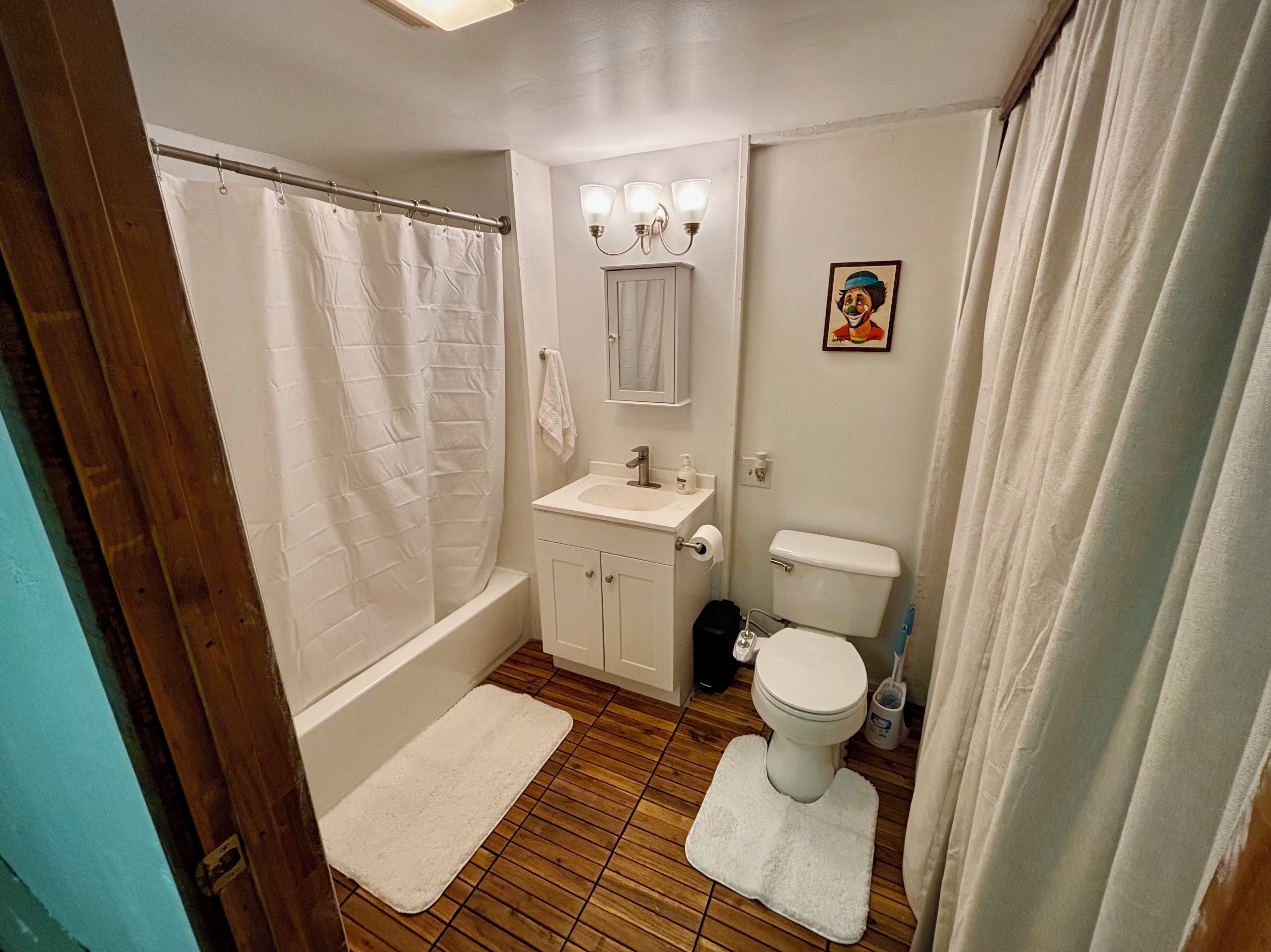 A bathroom with a bathtub, toilet, sink, and shower curtain.