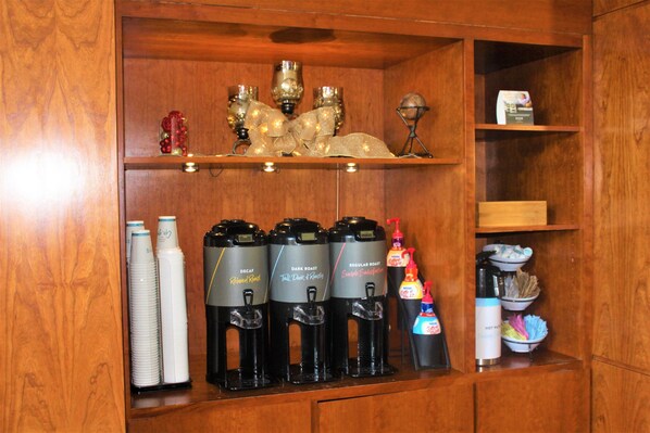 A coffee station with four dispensers labeled 'Decaf,' 'Dark Roast,' 'Regular Roast,' and 'Simple Espresso.'