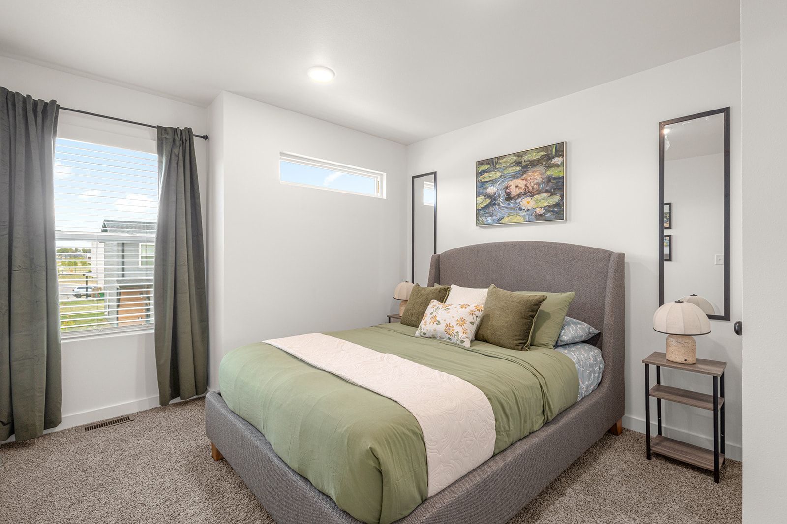 A bedroom with a bed, curtains, a window, a painting, and a nightstand.