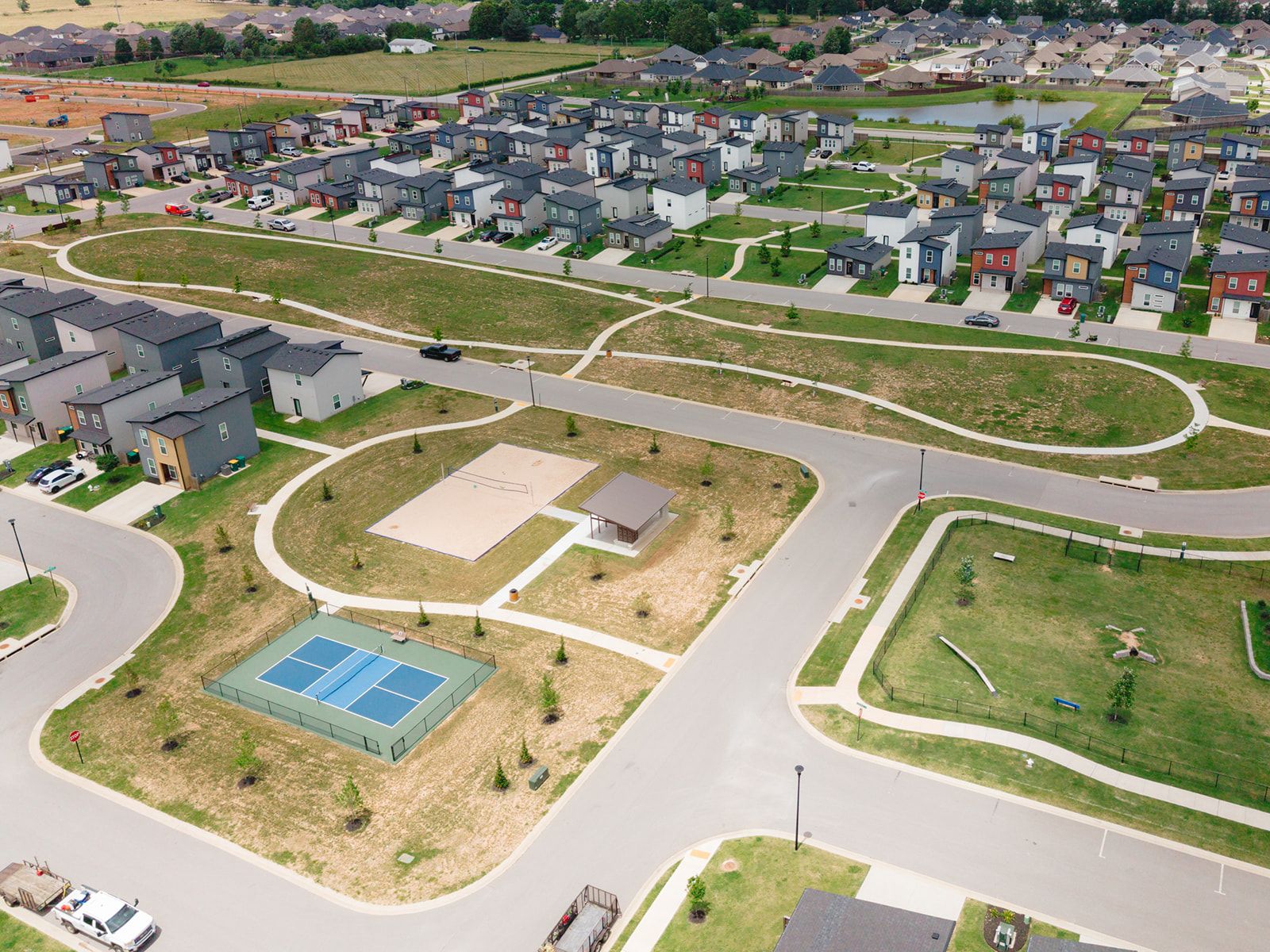 A residential area with houses, roads, and a sports court.