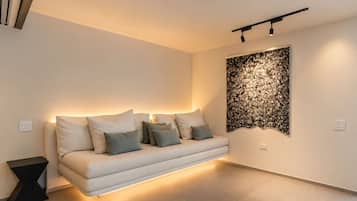 A modern living room with a sofa, a decorative wall piece, and a black side table.