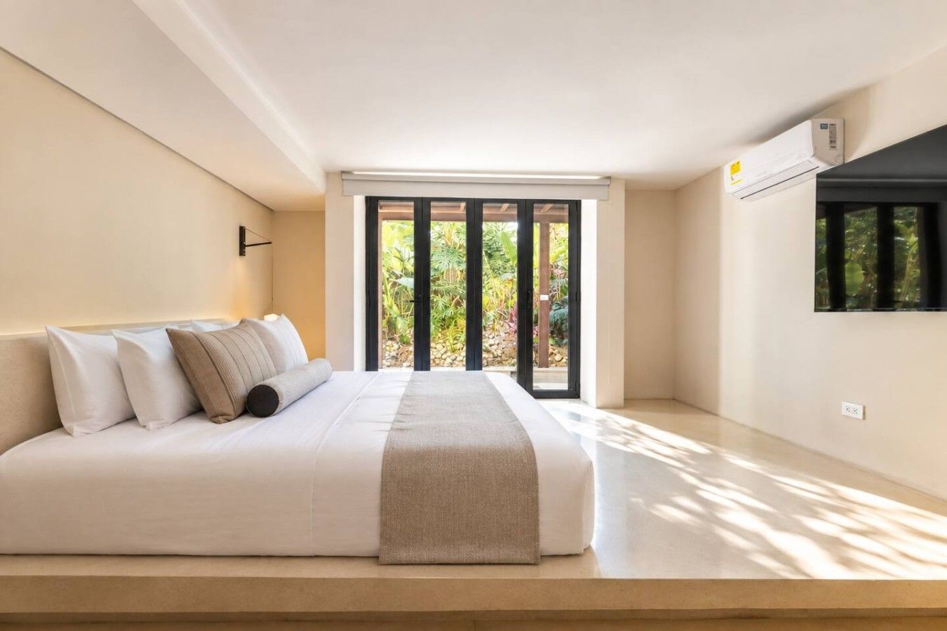 Ein Schlafzimmer mit einem Bett, einem Fenster und einer Klimaanlage.