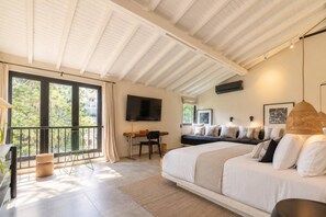 Un dormitorio moderno con una cama grande, un escritorio y un balcón.