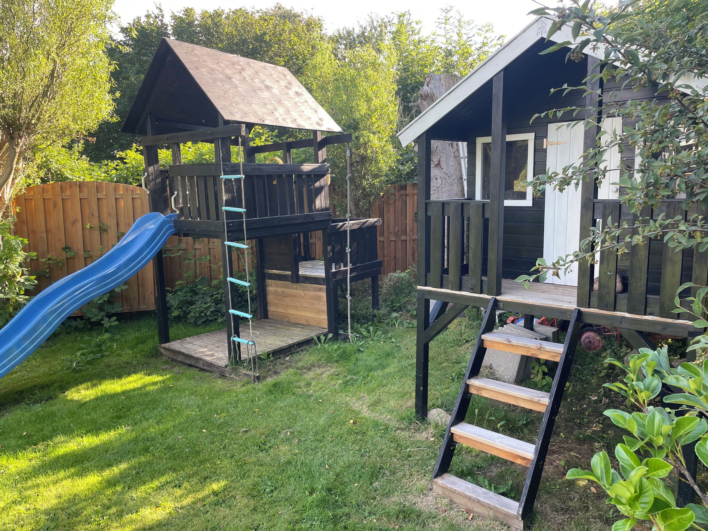 A wooden play structure with a slide and a climbing ladder.
