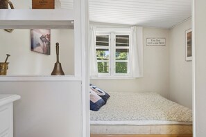 Ein Schlafzimmer mit einem Bett, einem Fenster mit Blick auf Grünflächen und einem Schild an der Wand.