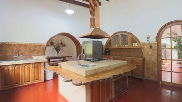 A kitchen with a central island, wooden cabinets, a built-in oven, and a large window.